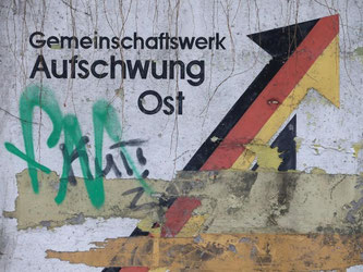 «Gemeinschaftswerk Aufschwung Ost» steht 25 Jahre nach der Einheit recht verwittert in Magdeburg. Foto: Jens Wolf