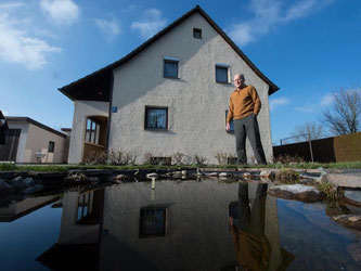 Ein Mann steht vor einem Haus der Siedlung «Am Dratfeld». Foto: Peter Kneffel