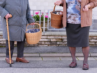 Zwei ältere Damen tragen nach einem Einkauf im mobilen Einkaufsladen in Hassenberg (Bayern) ihre Lebensmittel nach Hause. Foto: David Ebener/Illustration