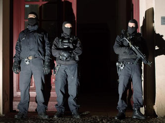 Mitglieder eines Polizei-Sonderkommandos vor einem Mehrfamilienhaus in Berlin. Über 200 Polizisten waren im Einsatz. Foto: Lukas Schulze