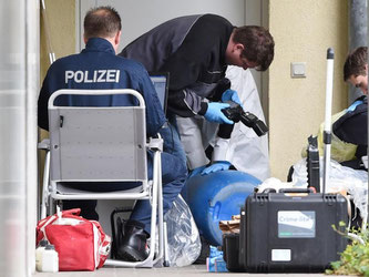 Sprengstoffexperten und Beamte der Spurensicherung arbeiten in Oberursel vor einer Wohnung. Foto: Boris Roessler