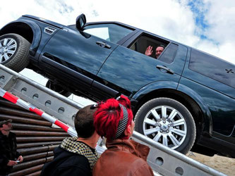 Land Rover präsentiert auf einer Automobilmesse seine Geländewagen auf einem Hindernisparcours. Foto: Hendrik Schmidt/Archiv