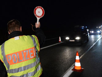 Ein Polizist stoppt durchfahrende Fahrzeuge, um Grenzkontrollen durchzuführen. Seit Sonntagabend kontrolliert Deutschland die deutsch-österreichische Grenze. Foto: Andreas Gebert