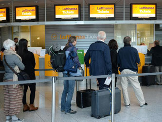 Flugreisende an einem Ticketschalter der Lufthansa im Flughafen München. Foto: Andreas Gebert