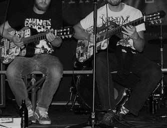 Die beiden Musiker mit Akustikgitarren auf der Bühne.