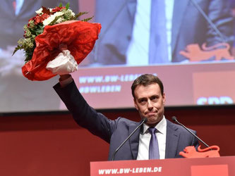 Nils Schmid winkt nach seiner Wiederwahl mit einem Blumenstrauß. Foto: Uwe Anspach