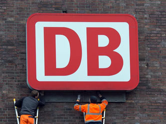 Monteure arbeiten an einem Unternehmensschild der Deutschen Bahn. Foto: Federico Gambarini/Archiv