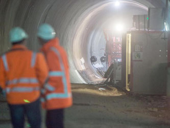 Zwei Mitarbeiter einer Firma sind während des Tunnelbaus zu sehen. Foto: Lino Mirgeler/Archiv