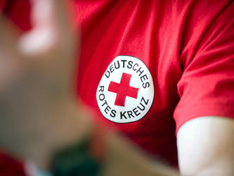 Blick auf rotes T-Shirt mit dem Logo des DRK. Foto: Arno Burgi/ Archiv