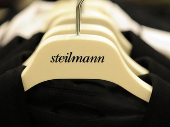 Kleiderbügel mit dem Logo von Steilmann hängen im Dortmunder Modehaus Boeker. Die Geschäfte laufen vorerst weiter. Foto: Bernd Thissen