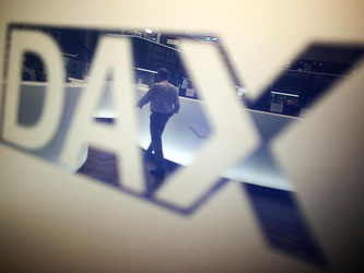 Ein Börsenhändler spiegelt sich im Logo des Deutschen Aktienindexes (DAX). Foto: Fredrik von Erichsen