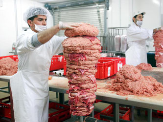 Arbeiter produzieren Döner-Spieße in einem Betrieb in Berlin. Foto: Gero Breloer/Archiv