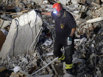 Die Helfer geben nicht auf und graben in den Trümmern der zerstörten Häuser. Foto: Maurizio Gambarini