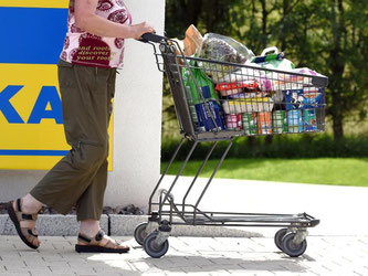 Eine Frau läuft mit ihrem Einkaufswagen an einem Edeka-Logo vorbei. Foto: Patrick Seeger/Archiv