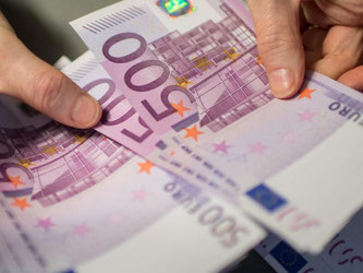 Eine Mitarbeiterin einer Bank zählt 500-Euro-Scheine. Foto: Matthias Balk/Illustration