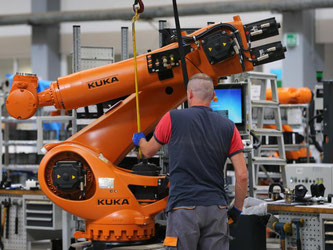 Roboter werden in der Produktion des Roboterbauers Kuka montiert. Foto: Karl-Josef Hildenbrand/Archiv