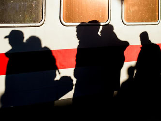 Die Schatten von Flüchtlingen nach ihrer Ankunft in Schönefeld. Foto: Patrick Pleul