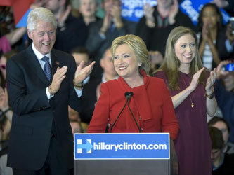 Hillary Clinton spricht in Des Moines. Im Hintergrund: Ihr Ehemann und Ex-Präsident Bill und Tochter Chelsea. Foto: Craig Lassig