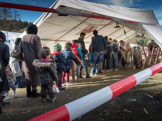 Neu eingetroffene Flüchtlinge warten nahe der oberösterreichischen Ortschaft Hanging auf ihre Nummerierung und den anschließenden Grenzübertritt nach Deutschland. Foto: Peter Kneffel