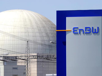 Hinter einem EnBW Logo ist ein Kernkraftwerk zu sehen. Foto: Uli Deck/Archiv
