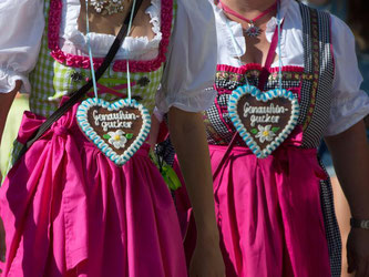Besucherinnen in Trachten gehen über das Cannstatter Volksfest. Foto: Sebastian Kahnert/Archiv