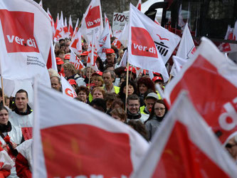 Mit Gewerkschafts-Fahnen laufen Hunderte Demonstranten. Foto: Ralf Hirschberger/Archiv