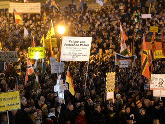 Anhänger der Pegida demonstrieren auf dem Theaterplatz mit Plakaten und Deutschland-Fahnen. Foto: Arno Burgi