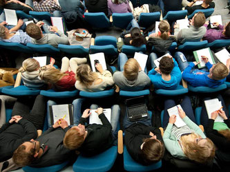 Studenten verfolgen eine Vorlesung. Foto: Julian Stratenschulte/Archiv