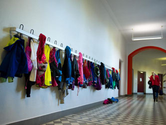 Jacken hängen in einer Schule in Stuttgart an einer Gaderobe im Flur. Foto: Inga Kjer/Archiv