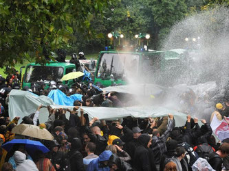 Ein Wasserwerfer spritzt auf Demonstranten. Foto: Marijan Murat/Archiv