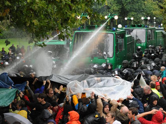 Ein Wasserwerfer zielt im Schlossgarten in Stuttgart auf Demonstranten. Foto: Marijan Murat/Archiv