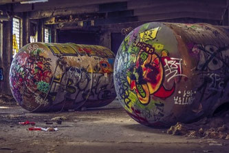 Alter, bunt lackierter und zweckentfremdeter Öltank in einer Industriehalle