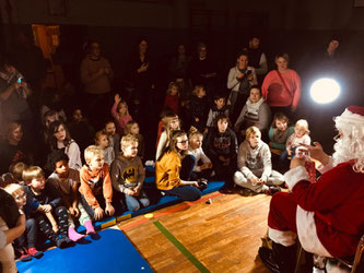 Weihnachtsmann vor Kinder.