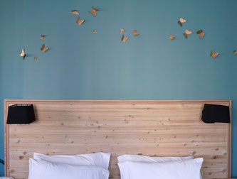 Détail, tête de lit en mélèze massif et papillons