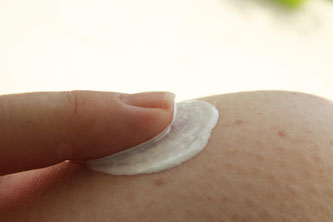 Sonnencreme wird am Knie aufgetragen