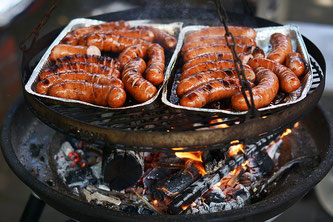 Wüsrstchen auf Aluminiumpfanne am Griller