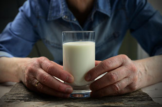Mann hält Milchglas