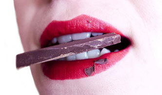 Frau hat Schokoladestück im Mund