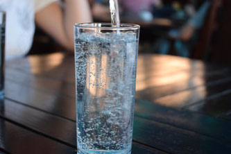 Mineralwasser wird in Glas eingeschenkt