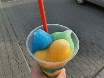 Kunststofftüte mit verschiedenfarbigen wässrigen Eissorten