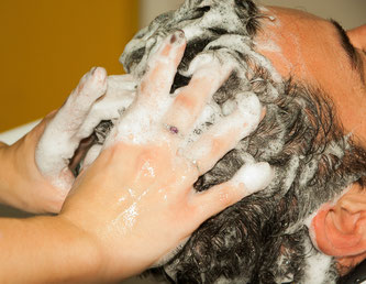 Die Haare eines Mannes werden gewaschen