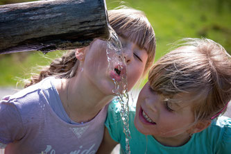 Kinder trinken Brunnenwasser