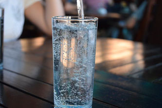 Ein Glas Mineralwasser wird eingeschenkt