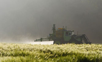 Traktor bei der Pestizidausbringung im Feld