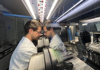 Empa-Forscher Enea Svaluto-Ferro arbeitet gemeinsam mit dem Batterieroboter «Aurora». Die Entwicklungszeit von neuen Stromspeichern soll so künftig stark verkürzt werden. Bild: Empa