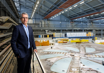 PSI-Direktor Christian Rüegg an der Abdeckung des Zyklotrons, das die dritte Beschleunigungsstufe für den weltweit einmaligen Protonenstrahl am PSI darstellt. © Scanderbeg Sauer Photography