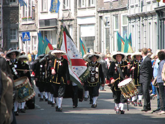 Sehenswürdigkeiten Europa: Niederlande. Im Bild: Traditionell gekleidete Männer mit Trommel und Fahne an einem Umzug in Maastricht.