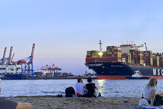 Containerschiffen in Hamburg vom Strand zusehen.