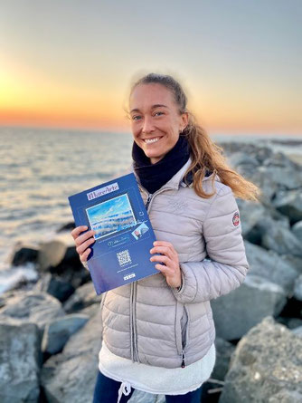 La campionessa mondiale di apnea ALESSIA ZECCHINI con il catalogo MAREARTE dove è stato pubblicato il suo disegno. L'opera originale è stata donata alla fondazione Cetacea per la charity.