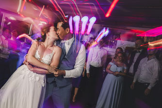 Außergewöhnliche Partyfotografie: Brautpaar küsst sich beim Hochzeitstanz
